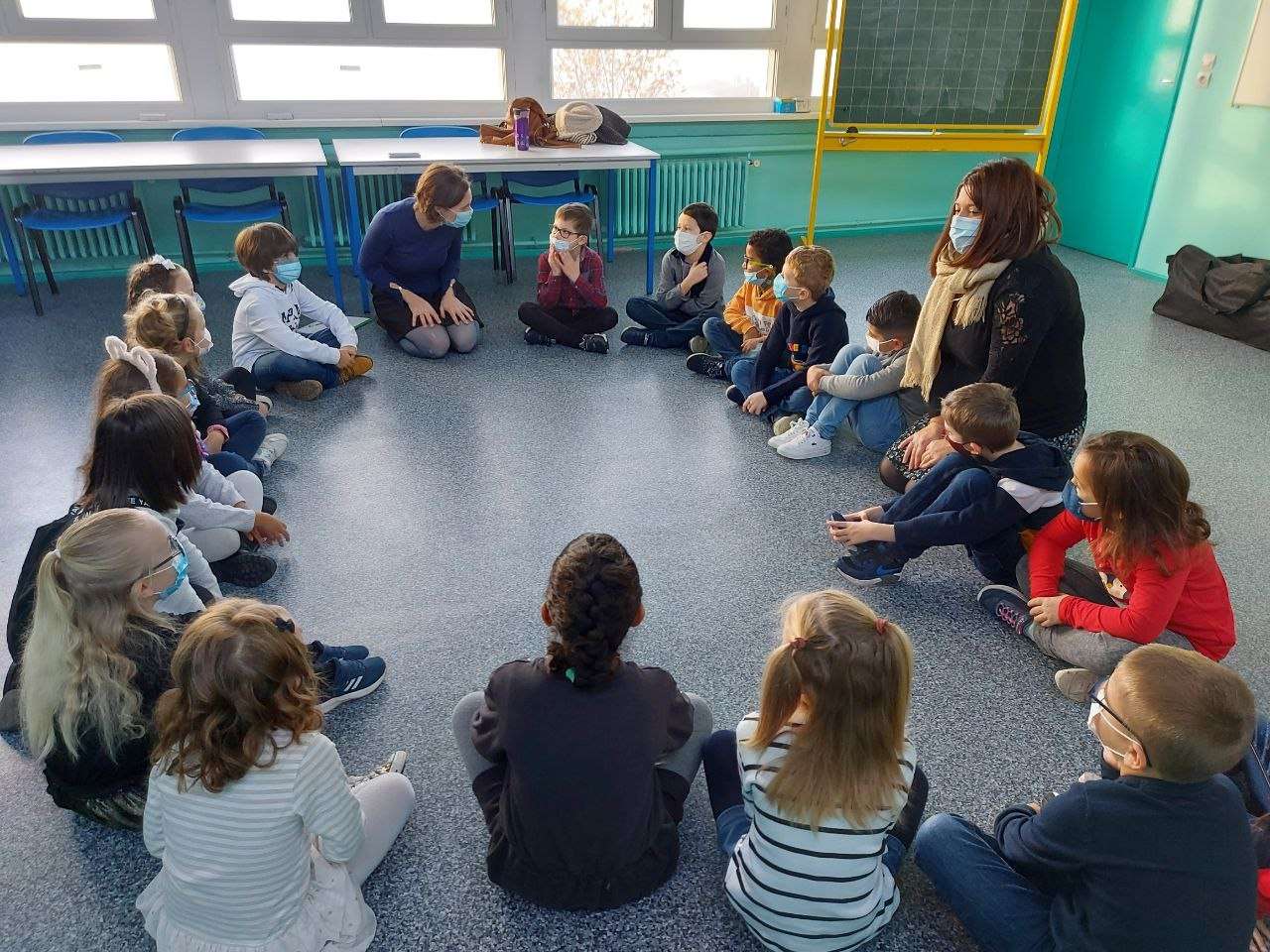 enfants assis en rond dans une classe